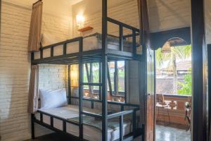 a room with a bunk bed with a window at In Da Lodge in Ubud