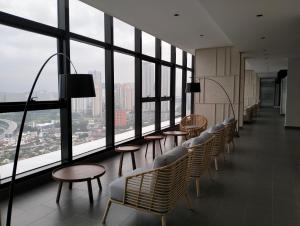 a row of chairs and tables in a room with windows at The Pano Jalan Ipoh Sentul by Kenangan Homes in Kuala Lumpur