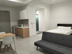 a bedroom with a bed and a table and a couch at The Pano Jalan Ipoh Sentul by Kenangan Homes in Kuala Lumpur