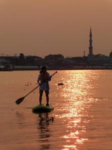 a person on a paddle board in the water at Baan GoLite Ko Kret - บ้านโกไล้เกาะเกร็ด in Nonthaburi