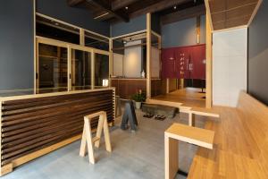 un bar con bancos y mesas en una habitación en Classic ＆ modern SELF-STYLED HOTEL 番場おおそね en Chichibu
