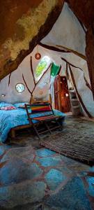 - une chambre avec un lit et une chaise dans une grotte dans l'établissement Finca Villa Beatriz, 