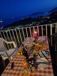 a table with food and a bottle of wine on a balcony at LA CASTELLANA Una Finestra sul Mare- Air Conditioned in Lerici