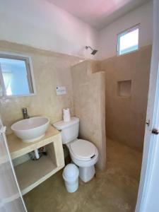 uma casa de banho com um WC e um lavatório em Barco Verde Hostel em Holbox