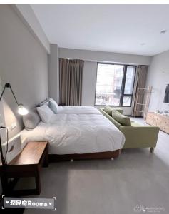 1 dormitorio con cama grande, mesa y sofá en Rooms Homestay en Hualien