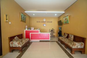 a waiting room with two couches and a large screen at RedDoorz Syariah @ Jalan Gajah Mada Meulaboh in Meulaboh