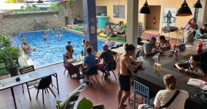 un grupo de personas sentadas en un bar en una piscina en The Funky Village en Siem Riep