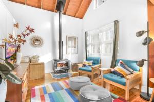 Cooee Cottage في بلاكيث: غرفة معيشة بها موقد وكراسي زرقاء