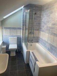 ein Badezimmer mit einer weißen Badewanne und einem WC in der Unterkunft Teviot Cottage 7 Fenton Hill Farm in Wooler