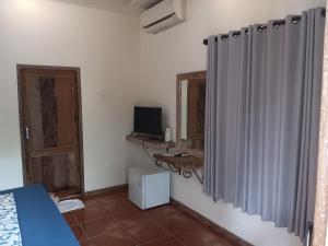 a bedroom with a bed and a television and a mirror at Mango 5 Hotel in Amed