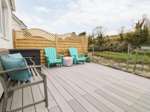 two chairs and a table on a wooden deck at Penpoll in Wadebridge