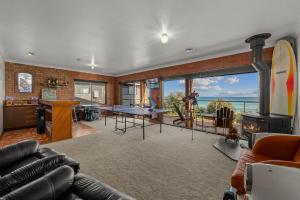 a living room with a pool table and a fireplace at Beachfront-private beach access and 180 degree bay views! in Chelsea