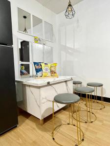 a kitchen with a counter with stools and a refrigerator at The Red Room 2bed room Condo in Imus