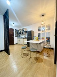 a kitchen with a counter and stools in a room at The Red Room 2bed room Condo in Imus