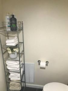 a bathroom with a rack with towels and a toilet at Quite and Spacious Apartment in Elizabeth