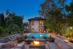 Luxurious Wine Country Estate في جييسيرفيل: حديقه خلفيه بها مسبح ومدفأة