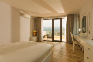 1 dormitorio con cama y escritorio con vistas en Mercury Beach DaNang, en Da Nang