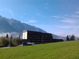 un bâtiment sur une colline à côté d'un champ verdoyant dans l'établissement Studio in Bad Mitterndorf - Steiermark 37017, à Bad Mitterndorf