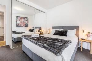 a bedroom with two beds and a large mirror at In the heart of Richmond - 1693 in Melbourne