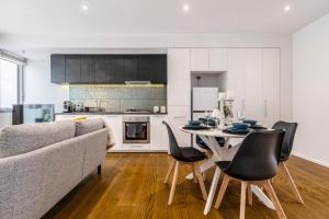 a living room with a couch and a table and chairs at In the heart of Richmond - 1693 in Melbourne
