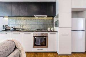 a kitchen with white cabinets and an oven at In the heart of Richmond - 1693 in Melbourne