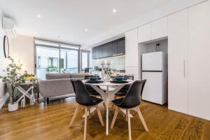 a kitchen and dining room with a table and chairs at In the heart of Richmond - 1693 in Melbourne