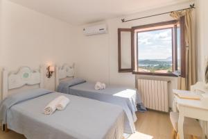 ポルト・チェルボにあるLa Casa Di Farinaの窓のある部屋にベッドが2つある