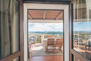 drzwi prowadzące na balkon ze stołem i krzesłami w obiekcie La Casa Di Farina With Pool Houses - Happy.Rentals w mieście Porto Cervo