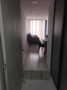 a hallway with a couch and a chair in a room at APARTAMENTO EN BUCARAMANGA, ZONA CENTRICA in Bucaramanga