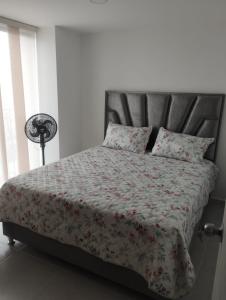 - une chambre avec un lit et une couette à fleurs dans l'établissement APARTAMENTO EN BUCARAMANGA, ZONA CENTRICA, à Bucaramanga