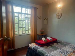 een slaapkamer met een bed en een raam bij Rania Lovely Hut Homestay Kundasang in Kampong Kundassan