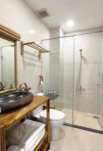 a bathroom with a glass shower and a toilet at Song Anh Indochina Studios Nguyen Thai Binh in Ho Chi Minh City