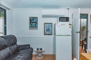 ein Wohnzimmer mit einem Sofa und einem Kühlschrank in der Unterkunft Dongara Hotel Motel in Dongara