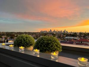 a group of candles on a ledge with a city skyline at Queensview168 Apartments Moonee Ponds in Melbourne