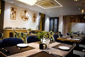 a restaurant with tables and chairs in a room at Hotel Azul Ganga in Rishīkesh