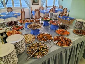 una mesa con muchos platos de comida. en Hotel Park Victoria, en Isquia