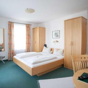 - une chambre avec un grand lit et une grande fenêtre dans l'établissement Hotel Egger-Stüberl, à Schechen