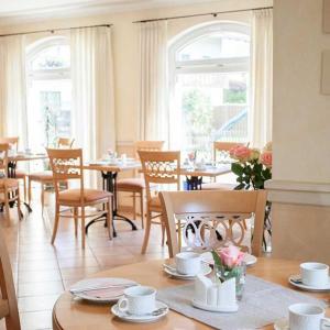 - une salle à manger avec des tables, des chaises et des fenêtres dans l'établissement Hotel Egger-Stüberl, à Schechen