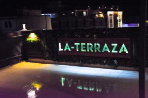 a sign that says la terraza on a fence at night at Hotel Azul Ganga in Rishīkesh
