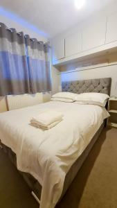 una camera da letto con un grande letto bianco e una finestra di Room in Guest room - Newly Built Private Ensuite In Dudley Westmidlands a Dudley