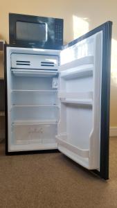 un frigorifero aperto con forno a microonde sopra di Room in Guest room - Newly Built Private Ensuite In Dudley Westmidlands a Dudley