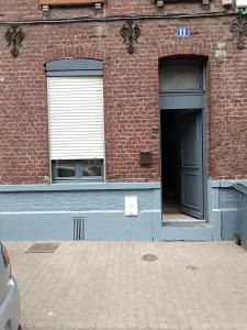 ein Backsteingebäude mit einer Tür und einem Fenster in der Unterkunft Chambres privatives avec espaces partagés dans maison Roubaix centre in Roubaix