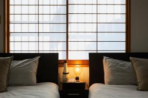 une chambre avec deux lits et une grande fenêtre dans l'établissement Japanese Tradition Hotel Evergreen, à Tokyo 39 autres photos