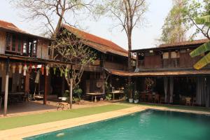 a house with a swimming pool in front of it at Capital O 75421 Baan Singkham Boutique Resort in Chiang Mai