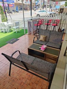 two beds and a table and chairs on a patio at Cafe Nana Hotel in Nong Prue