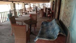 a patio with chairs and a table with a pillow at boddenbackpacker in Bartelshagen