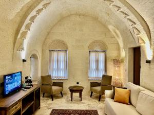 a living room with an archway with a couch and chairs at Sinasos Evleri in Nevsehir