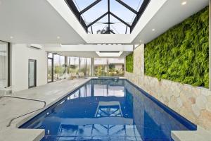 a swimming pool in a house with a green wall at Great Ocean Road Resort in Anglesea