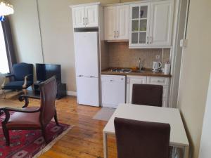 uma cozinha com um frigorífico branco, uma mesa e cadeiras em Agus Flats Galata em Istambul