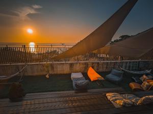a view of a sunset from a deck with a hammock at 濱境行旅 Begin Inn in Xiaoliuqiu